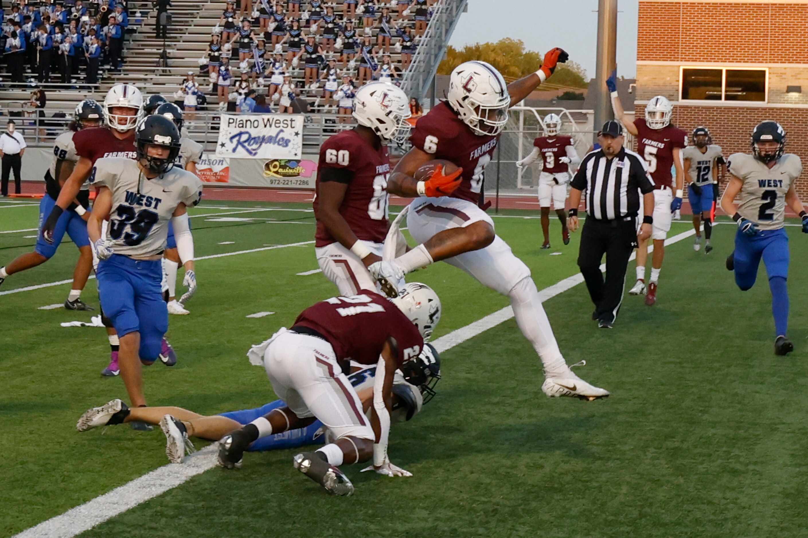 Lewisville’s Damien Martinez leaps over a Plano West defender to score a touchdown during...