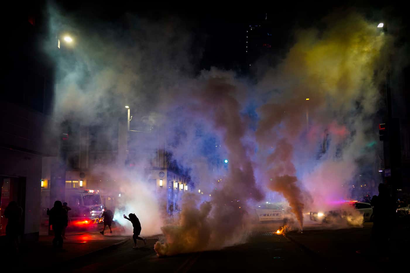 Tear gas is deployed by Dallas police to disperse a group of people at the corner of Akard...
