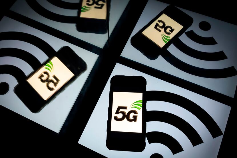 The 5G wireless technology logo is displayed on a smartphone and a wireless signal sign is...