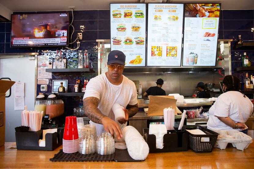 Owner Wes Williams restocks lids at BurgerIM on Sunday, May 31, 2020 in Dallas. Many in the...