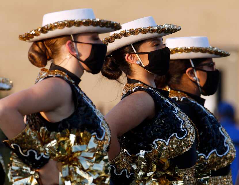 Members of the Kaufman Lions drill team sport face masks before taking the field for team...