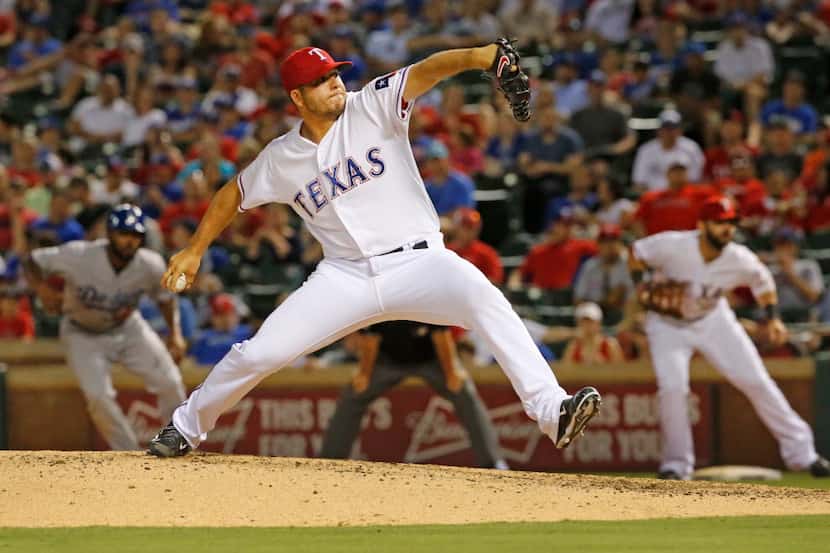Texas pitcher Shawn Tolleson, center, closes out the ninth inning for a save in the Rangers'...