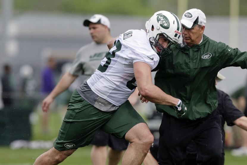 New York Jets tight end Jace Amaro, left, pushes past coach Steve Hagen during the team's...