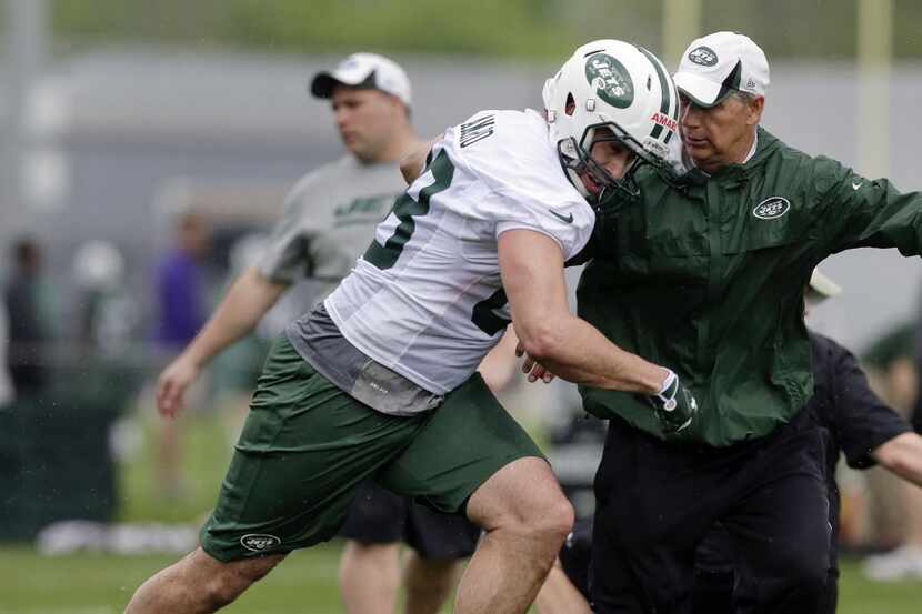 New York Jets tight end Jace Amaro, left, pushes past coach Steve Hagen during the team's...