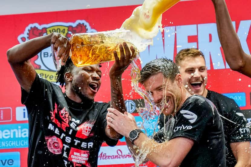 Jugadores del Bayer Leverkusen festejan con su entrenador Xabi Alonso tras ganar el título...