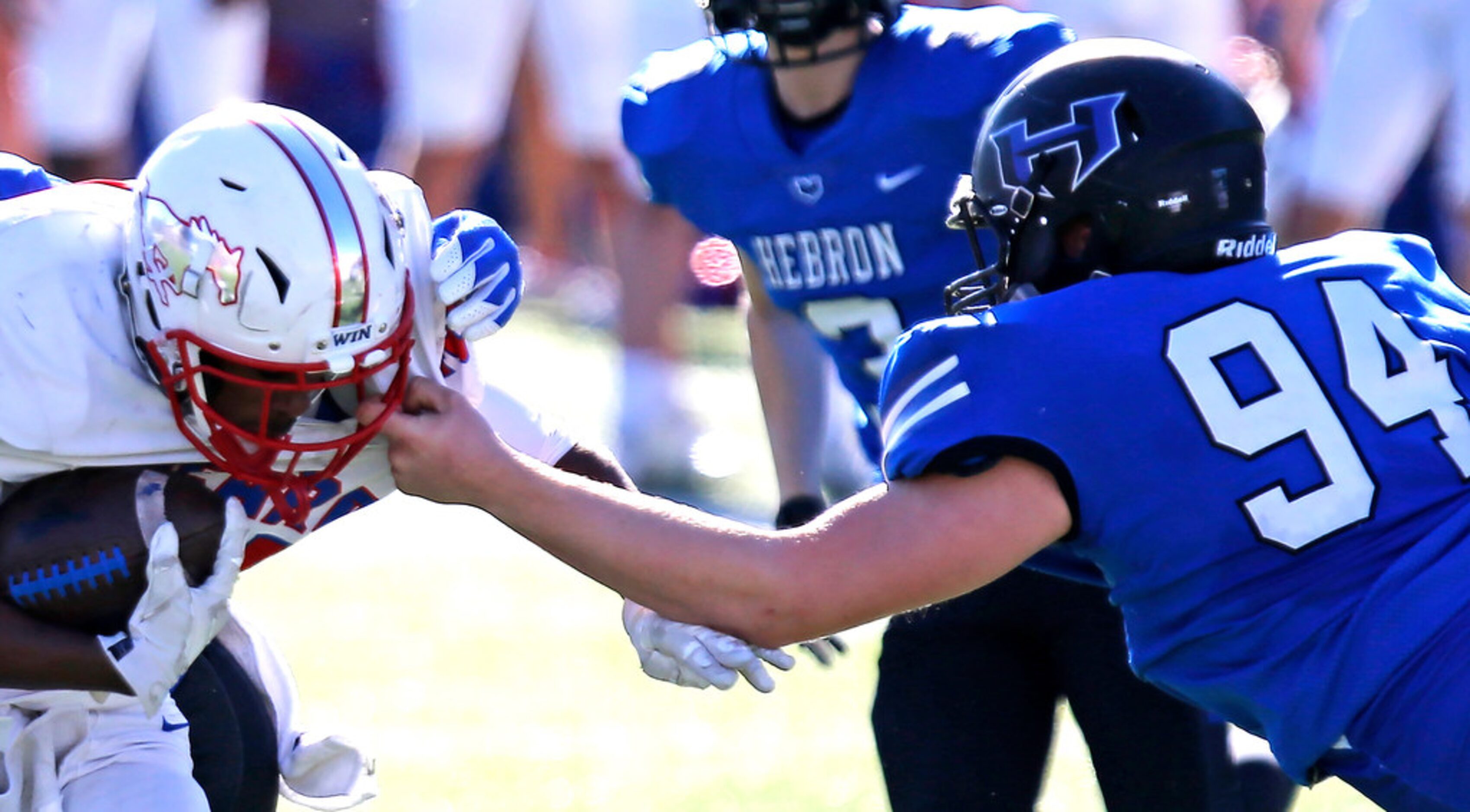 Pearce High School running back Dequan Landon (45) is face masked by Hebron High School...