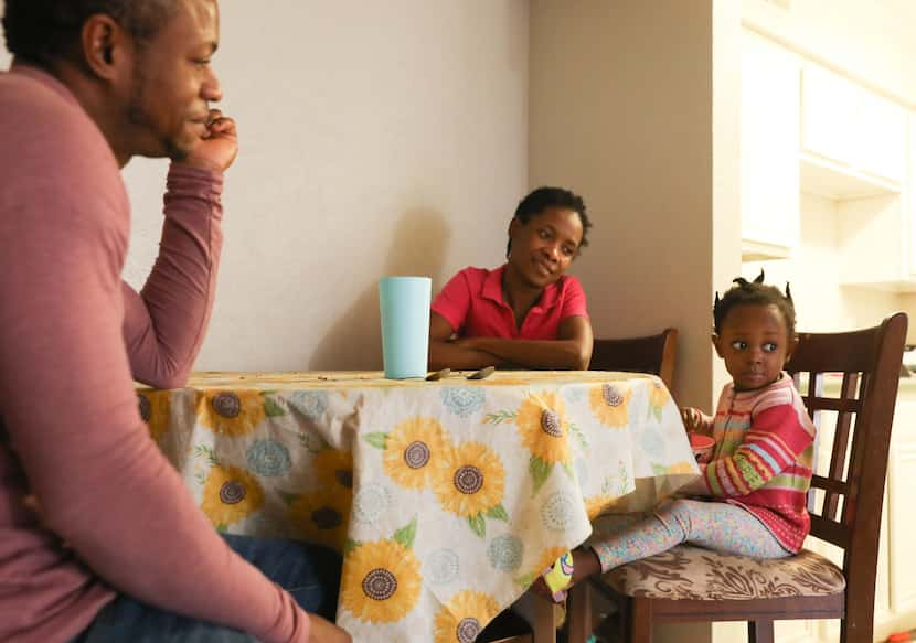 Berno Cherestan (left), Bennia Celestin (center), and Bernie Cherestan (right), 2, sit at...