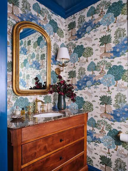 Powder bathroom interior with bold chinoiserie wallpaper and an antique bureau converted to...