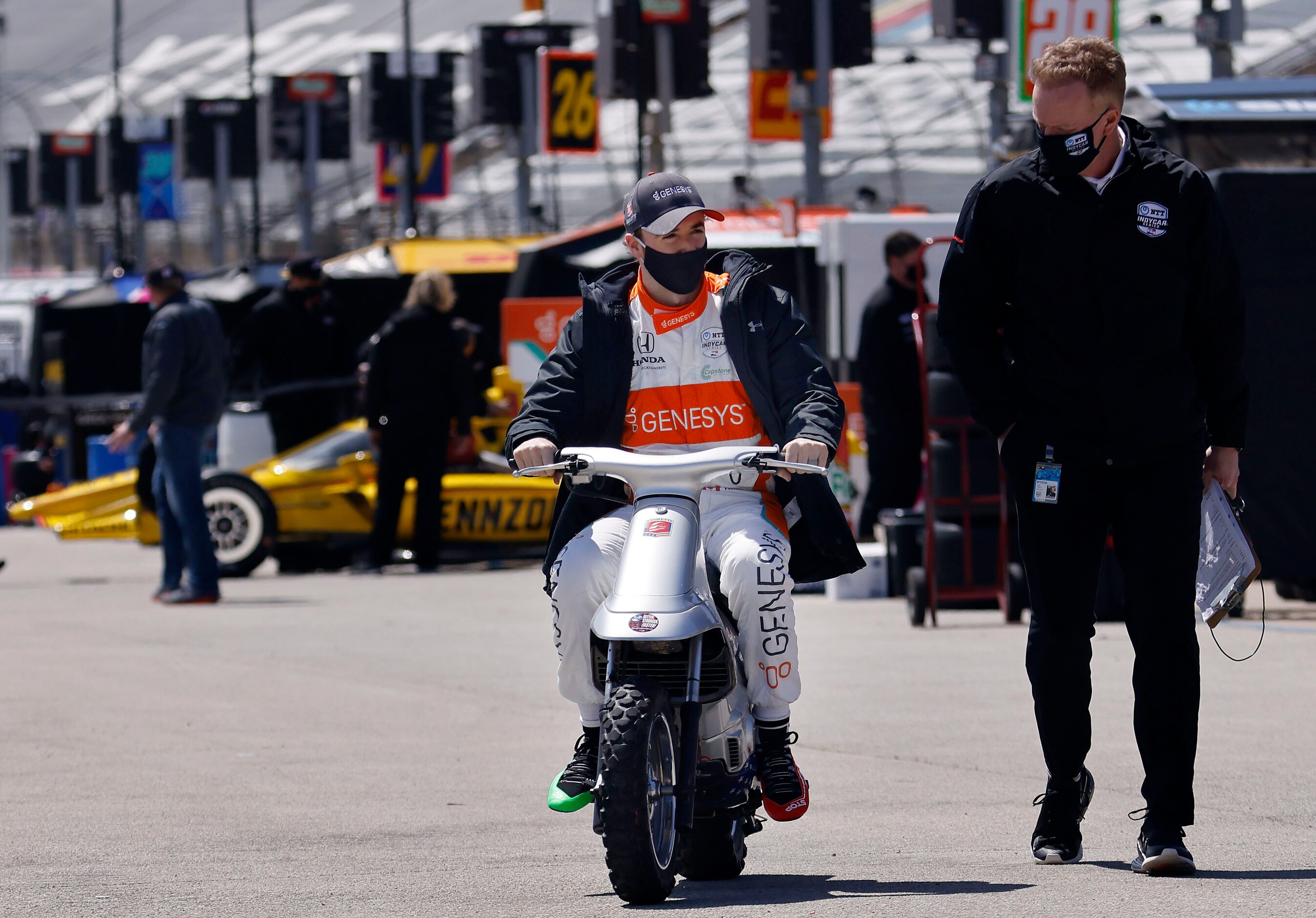 Indy Car driver James Hinchcliffe rides his motorbike down the pits after his practice...