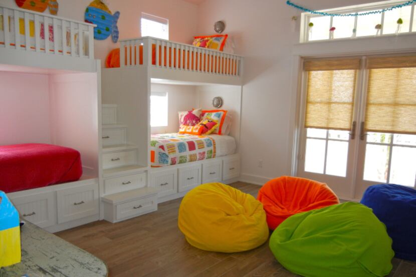 A bunk room in a waterfront house in Port Aransas uses splashes of color to warm up the big...