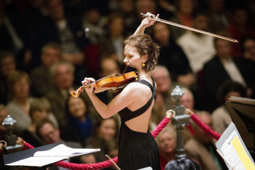 With Jaap van Zweden conducting, left, Violinist Hilary Hahn performs with the Dallas...