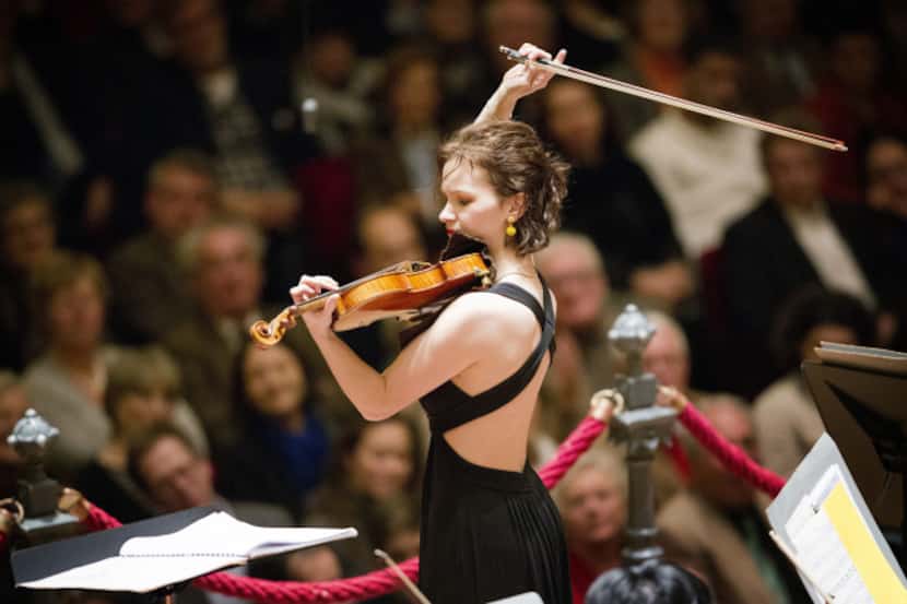With Jaap van Zweden conducting, left, Violinist Hilary Hahn performs with the Dallas...