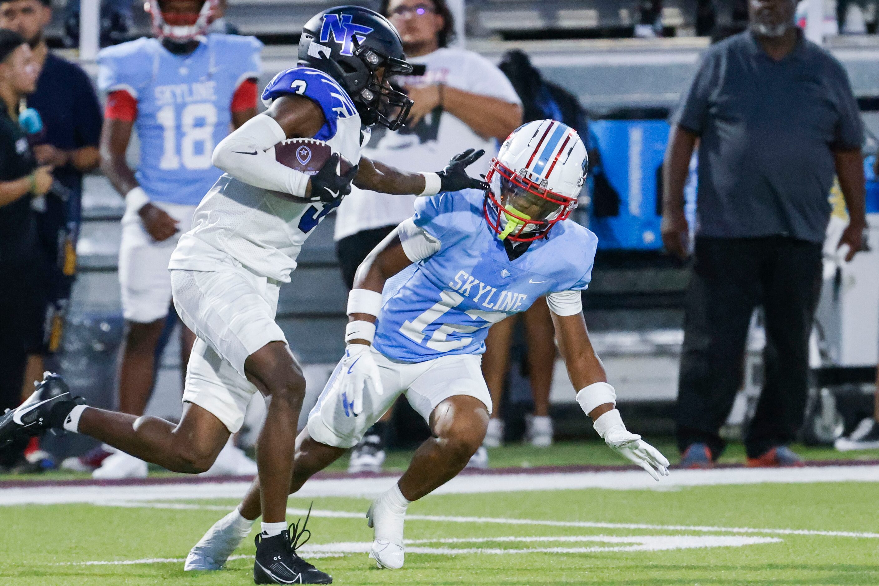 North Forney High’s Eli Otieno (left) reaches to stiff arm Skyline High’s Lemond Smith...