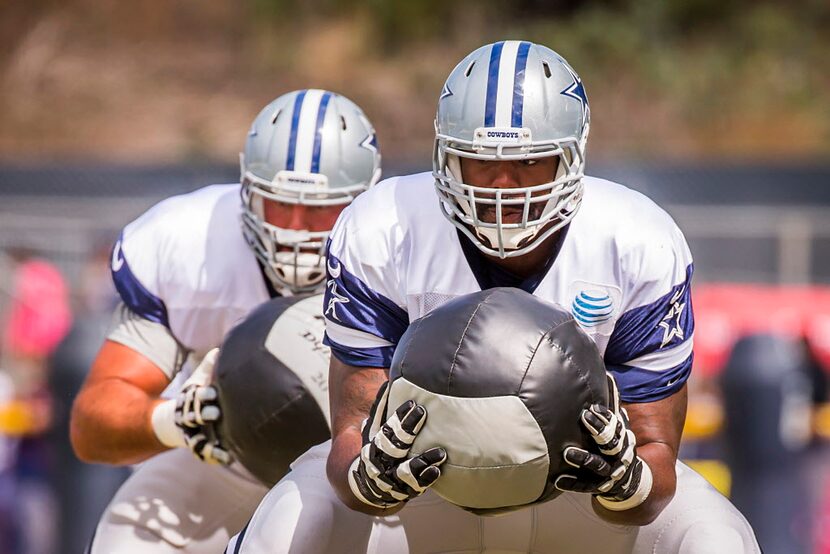 Dallas Cowboys tackle Tyron Smith (77) and guard Ronald Leary (65) run a drill carrying...