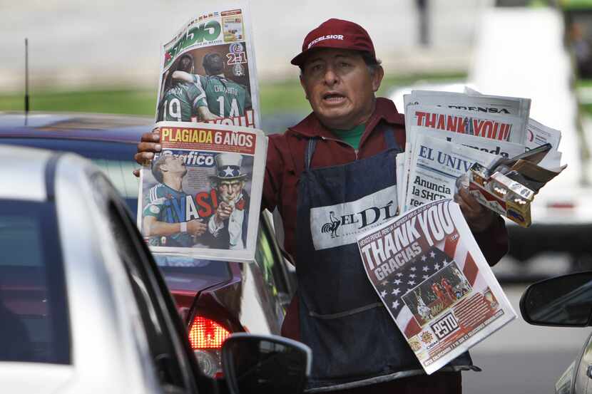 Joel Marquez sells local newspapers with front pages thanking the U.S. soccer team in Mexico...