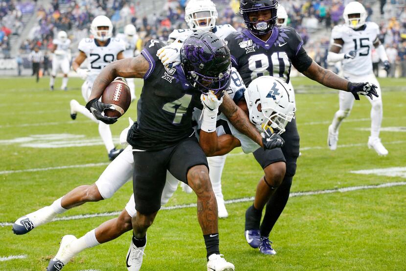 TCU Horned Frogs wide receiver Taye Barber (4) stiff arms West Virginia Mountaineers...
