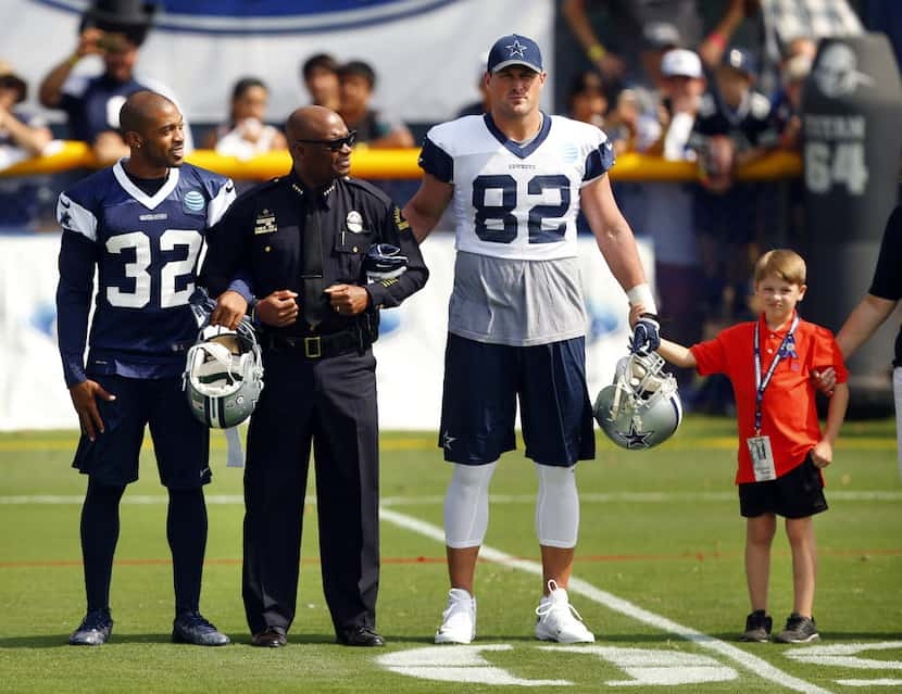 Dallas police Chief David Brown (second from left) walked arm-in-arm with Dallas Cowboys...