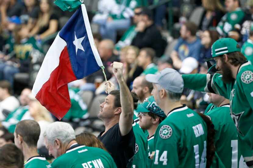 Dallas Stars fans wave a Texas flag as the clock winds down in the third period during the...