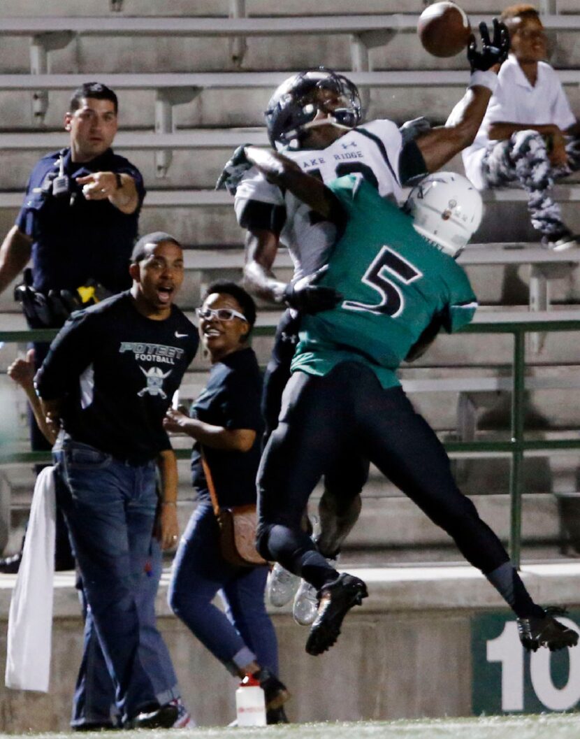 Sideline personnel and an officer in the stands react as Mesquite Poteet High defender...