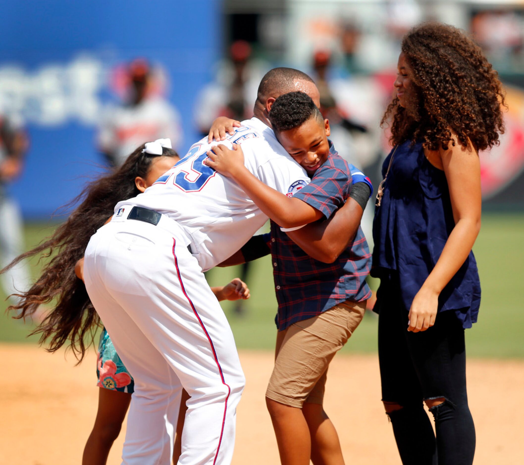 Texas Rangers Adrian Beltre (29) hugs his son Adrian Jr. and daughters Canila (left) and...