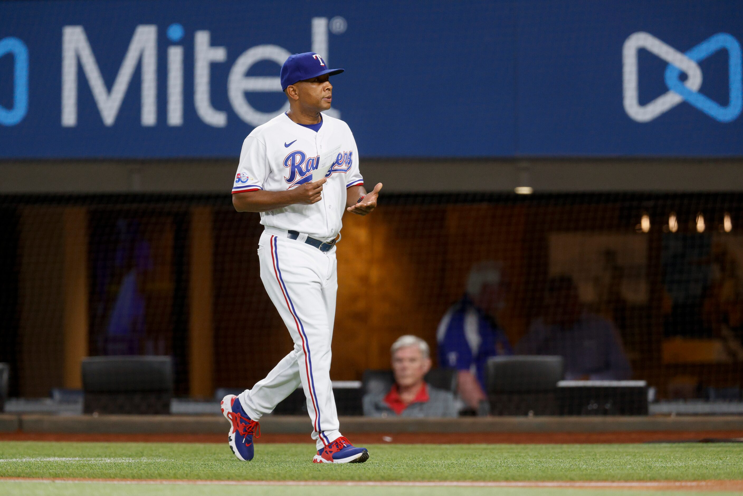 Texas Rangers interim manager Tony Beasley (27) walks to deliver his lineup card before a...