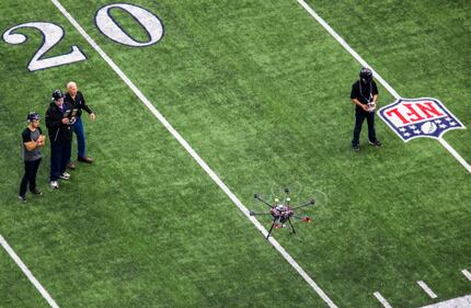 Javier Gutierrez (from left), Richard Cox, Ron Wingo and Taylor Ellis fly a drone around...