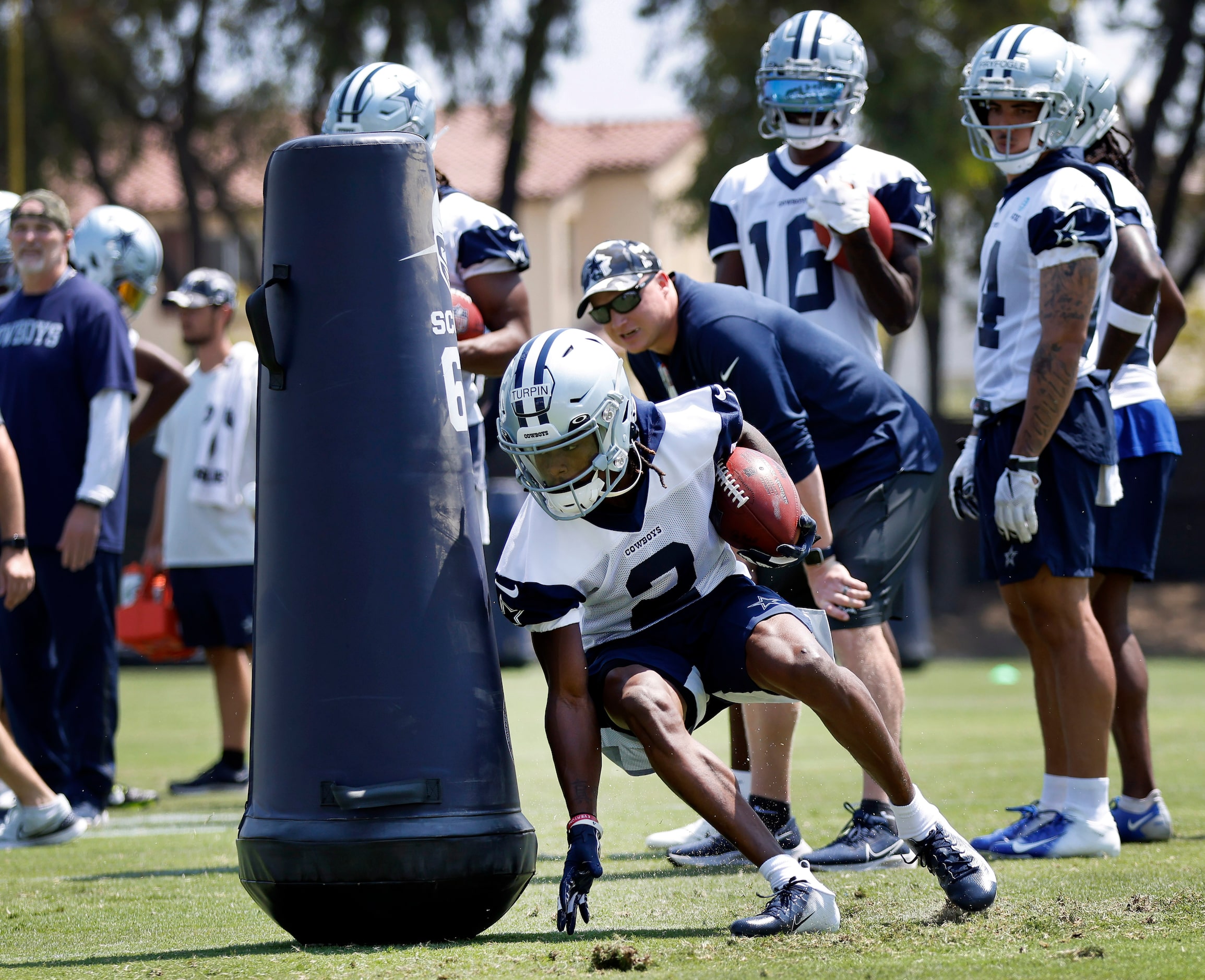 Dallas Cowboys wide receiver KaVontae Turpin digs around a blocking dummy as he carries the...