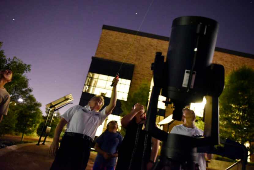 Dennis Wardell usa un laser para dar una explicación sobre los planetas a Jennifer Avitia y...