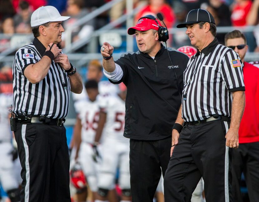 Cedar Hill head coach Joey McGuire, center, disputes a call with officials during the second...