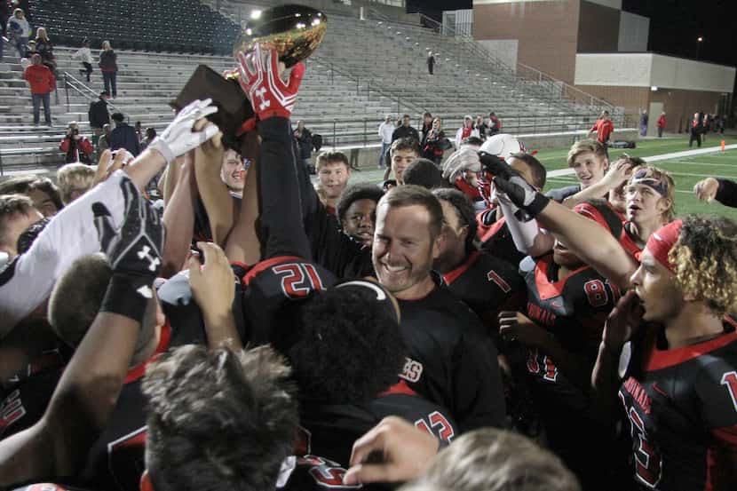 Melissa head coach Seth Stinton was all smiles as he raised the bi-district trophy as he...