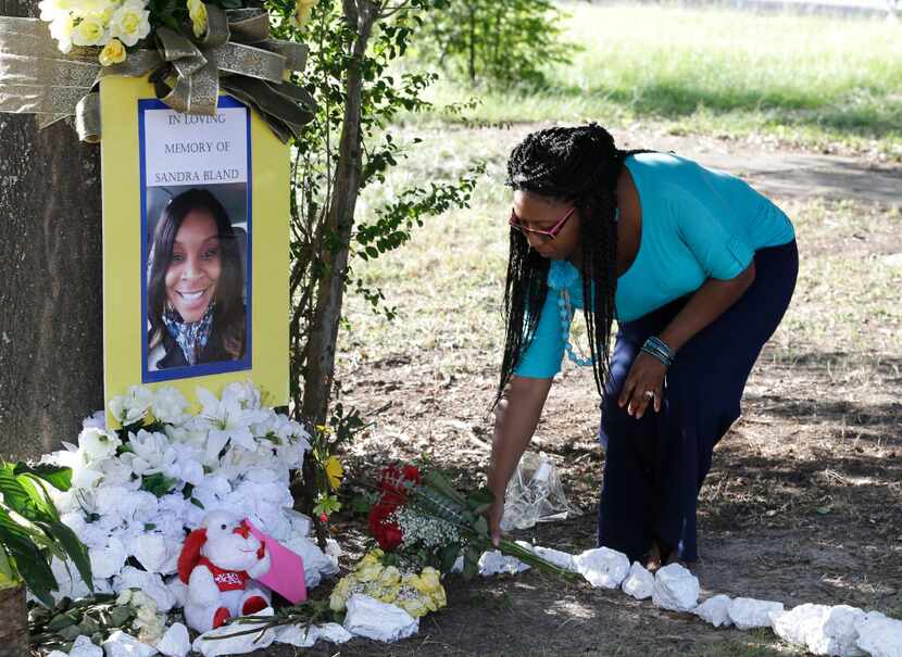 In this July 21, 2015 photo, Jeanette Williams places a bouquet of roses at a memorial for...