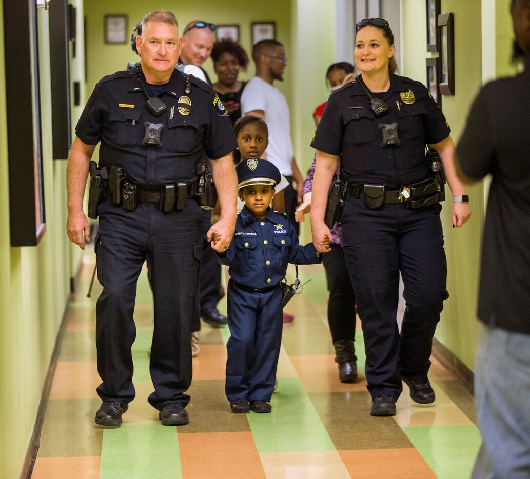 Four-year-old Ah'Maya Terrell was flanked by Lt. John Densmore and Cpl. Kristine Hill during...