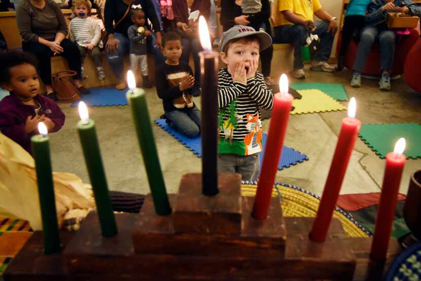Henry Flynn, 3, of Dallas, reacts to a traditional Kwanzaa candle lighting during a special...
