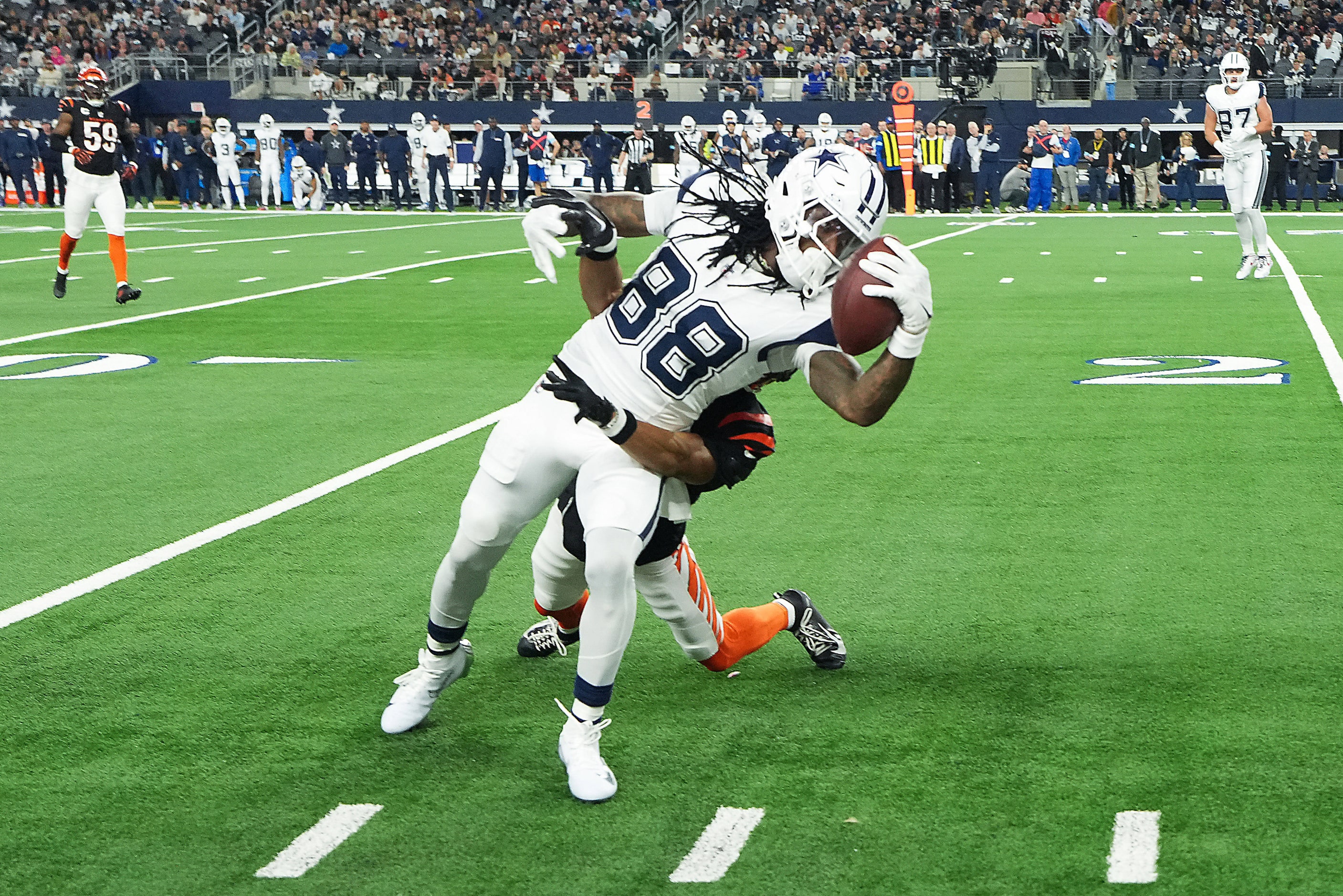 Dallas Cowboys wide receiver CeeDee Lamb (88) is pulled down along the sidelines during the...