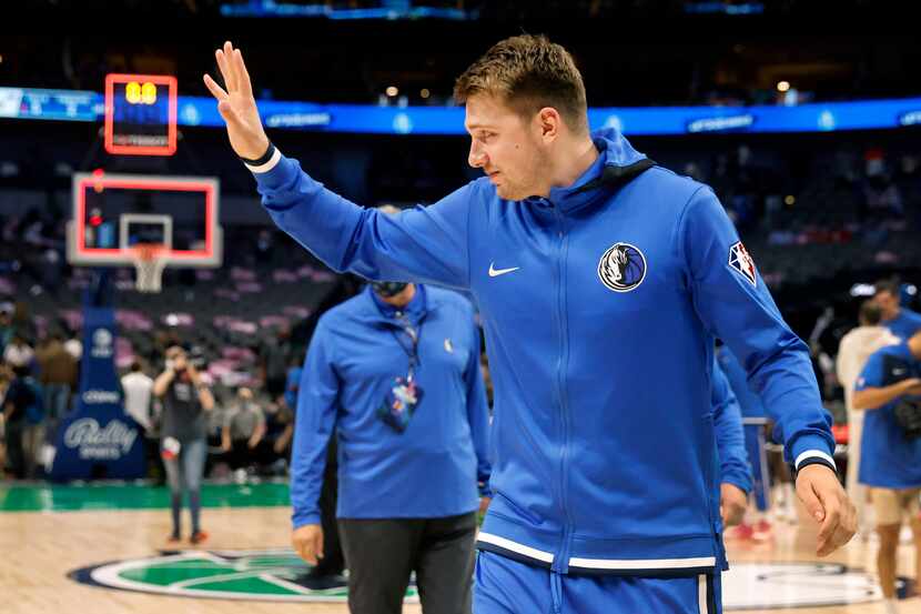 Dallas Mavericks guard Luka Doncic waves to fans as he leaves the court following a...