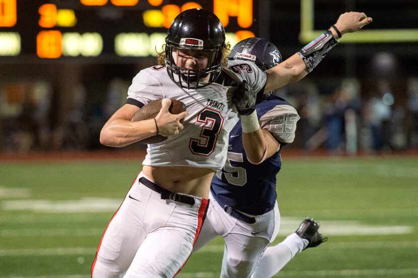 Euless Trinity senior quarterback Noah Wineteer (3) is pulled down from behind by Flower...