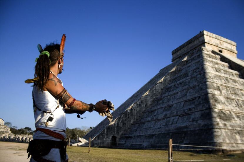 In this March 20, 2010 file photo, a man performs a ritual as he looks toward the descent of...