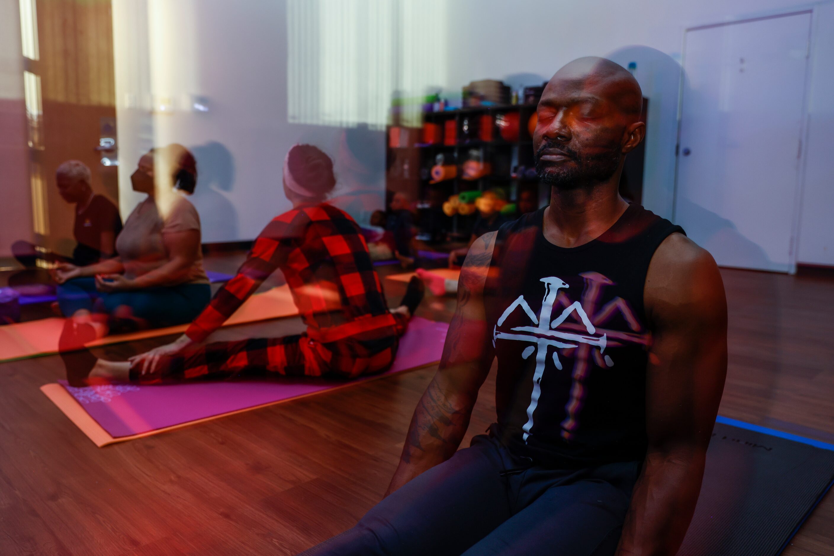 In darkness, participants including Fredrick Robinson of Grand Prairie participate in a yoga...