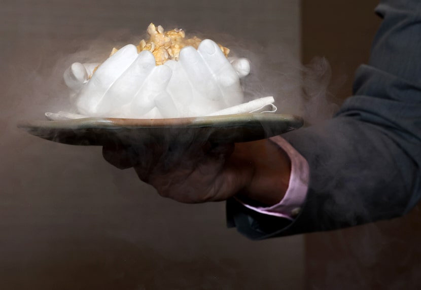 Liquid nitrogen fog spills off of a serving of Cattle Corn, which consists of caramel corn...