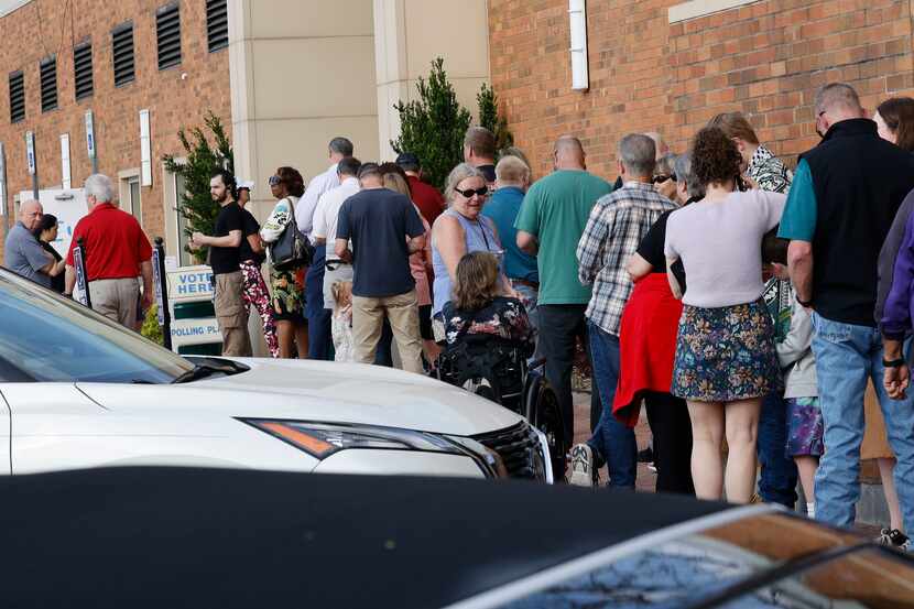 Voters line up at a polling site to vote in the state's primary election at Allen Municipal...