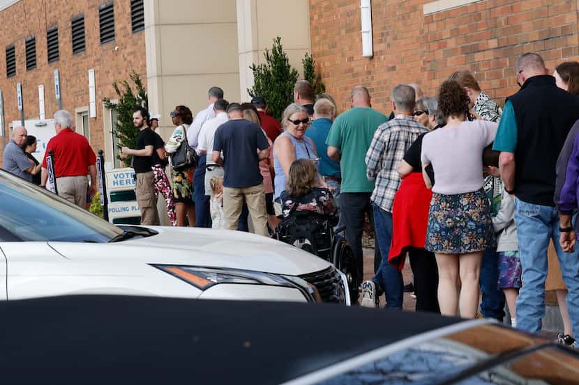 Voters line up at a polling site to vote in the state's primary election at Allen Municipal...