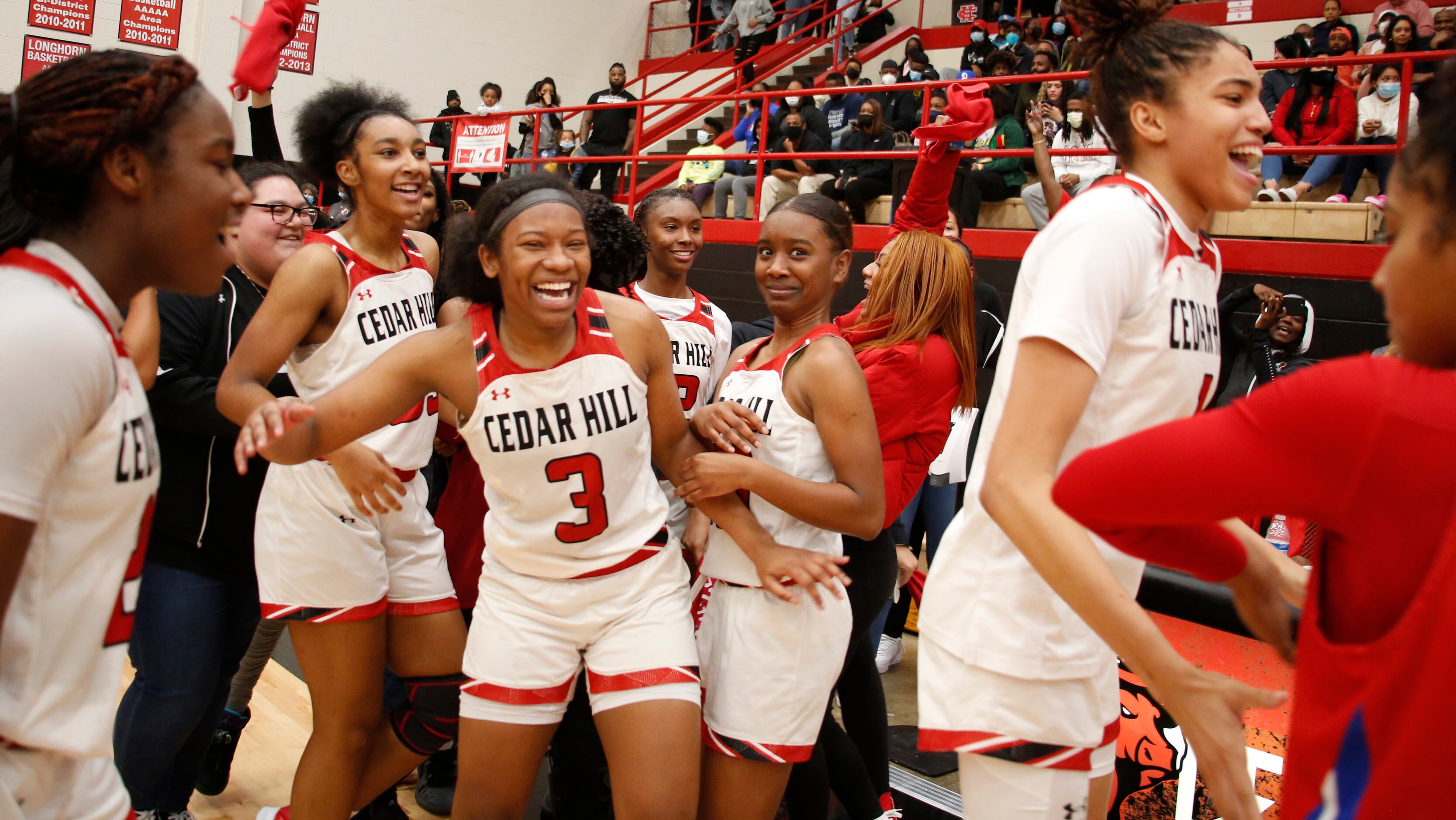 Cedar Hill players celebrate on the court following their 80-72 victory over Duncanville....