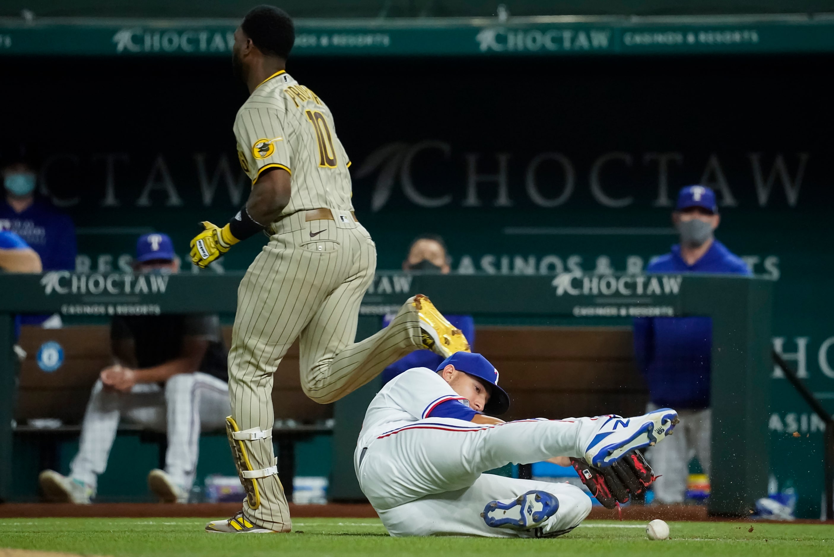 Texas Rangers pitcher Brett Martin can’t make the play on a single off the bat of San Diego...