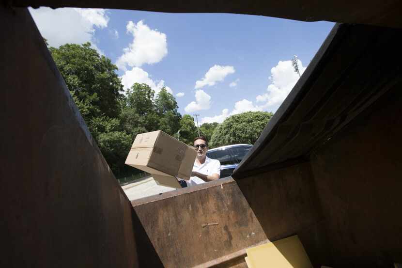JosÃ© Cavazos, of Dallas, tosses recyclable waste in to a Dallas Sanitation Services...