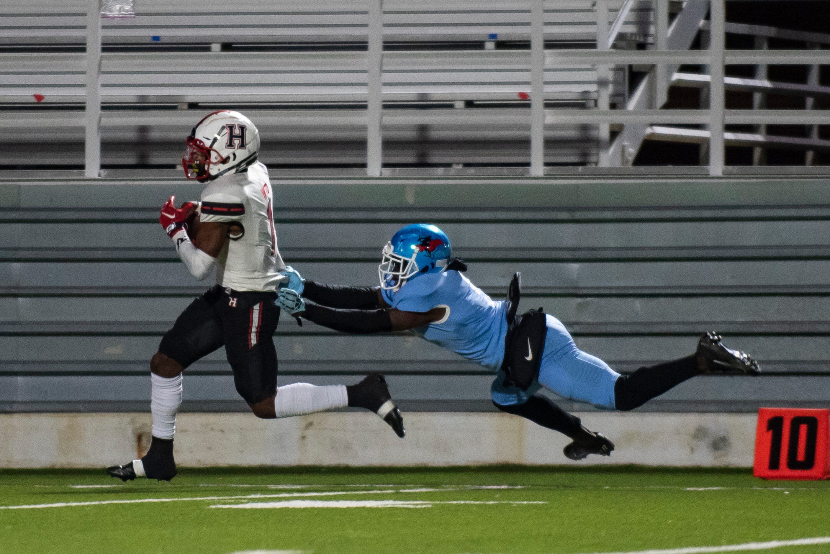 Heath senior Jay Fair (1) runs down the sideline as Skyline senior Gregory Johnson (5)...