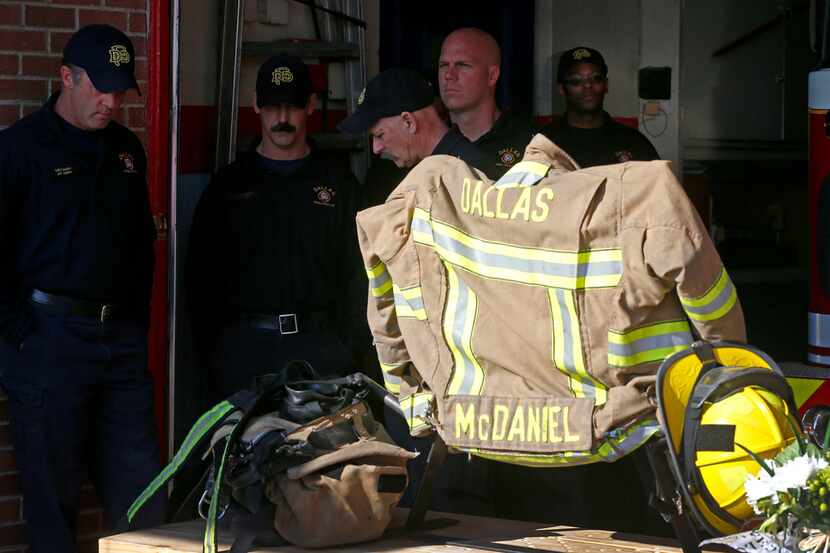Lieutenant Ray Smith (left) and other firefighters wait to speak to the media during a news...