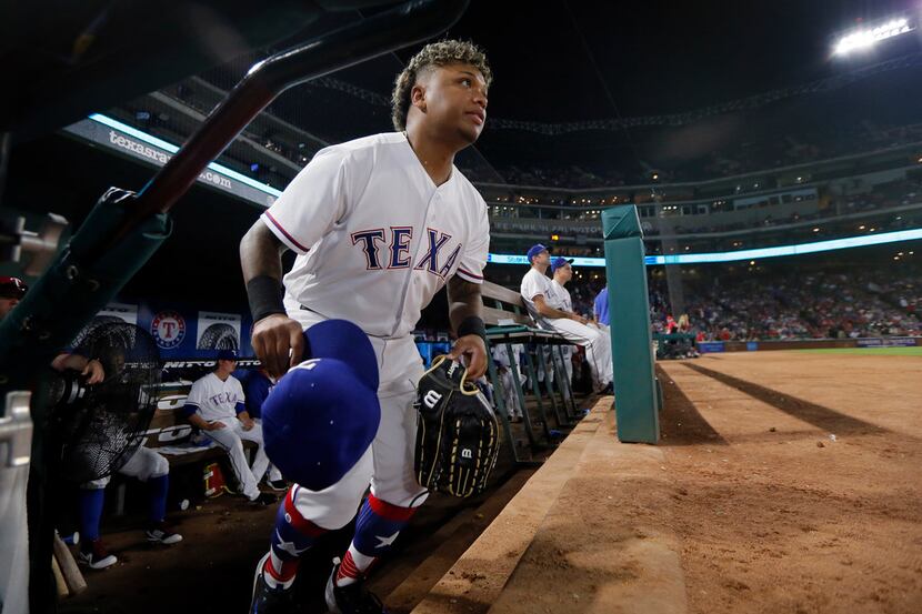 Texas Rangers left fielder Willie Calhoun heads out of the dugout for the fourth inning of...