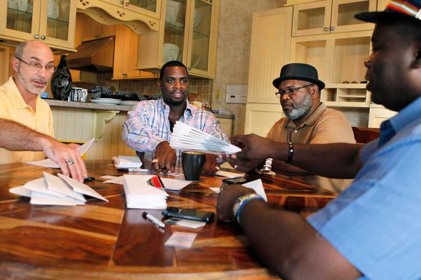 Exoneree and Director of House of Renewed Hope Christopher Scott (second from left) prepares...