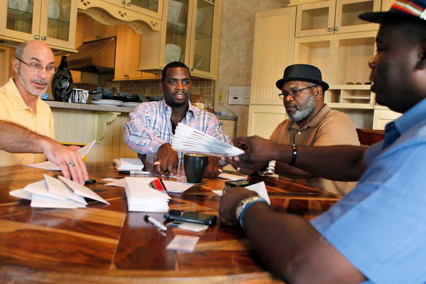 Exoneree and Director of House of Renewed Hope Christopher Scott (second from left) prepares...