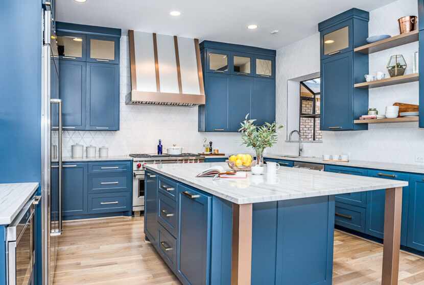 A kitchen with white countertops and walls features blue cabinets.